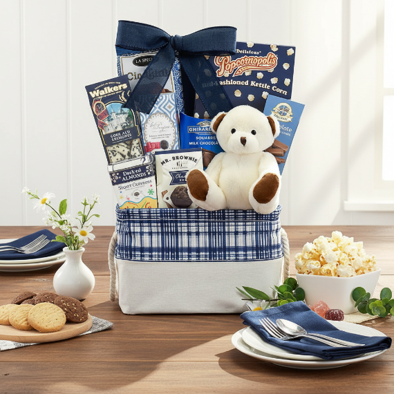 Gift basket with snacks, a teddy bear, and popcorn on a table.