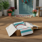 Decorative towels with a message on a wooden surface in front of a house with a teal door.