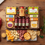 Gift box with assorted cheeses, meats, and crackers on a wooden table