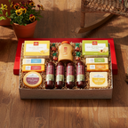 Gift basket on a wooden floor with potted plants and a chair in the background