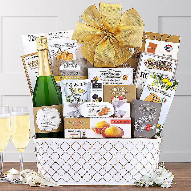 Gourmet gift basket with champagne, snacks, and a decorative bow on a wooden table.